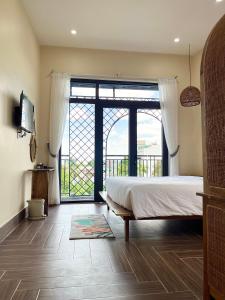 a bedroom with a large bed and a large window at Hue Sweethouse 2 Homestay in Hue