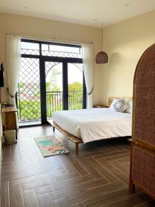 a bedroom with a bed and a large window at Hue Sweethouse 2 Homestay in Hue