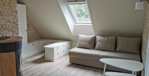 a living room with a couch and a window at Neringarent Apartamentai in Juodkrantė