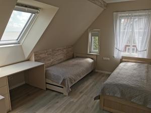 a bedroom with two beds and two windows at Neringarent Apartamentai in Juodkrantė