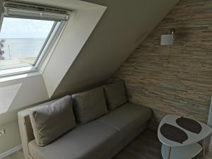 a living room with a couch and a window at Neringarent Apartamentai in Juodkrantė +28 photos