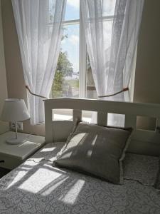 a bedroom with a bed and a large window at Neringarent Apartamentai in Juodkrantė