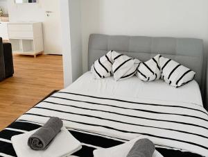 a bed with black and white pillows on it at Casa Porto in Piran