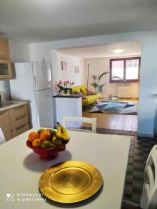 a kitchen with a bowl of fruit on a table at La Chicca 5 posti letto in Capannori
