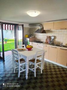 a kitchen with a white table and chairs in a kitchen at La Chicca 5 posti letto in Capannori