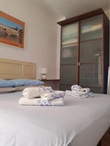 ein weißes Bett mit Handtüchern darüber in der Unterkunft Double Two de' Magnoli in Florenz