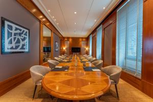 une salle de conférence avec une grande table et des chaises dans l'établissement Beau Rivage Hotel, à Neuchâtel