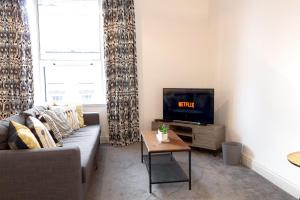 a living room with a couch and a tv at Chic Centrally Located 1 Bed Apt in Chester in Chester