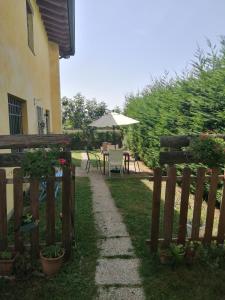 a garden with a fence and a table with an umbrella at Alle porte di Marano in Marano