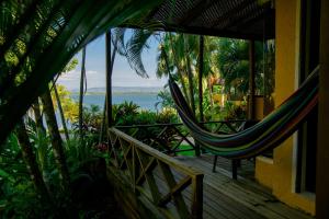 a hammock on a porch with a view of the ocean at Banana Palms Hotel in Río Dulce