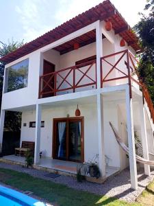 a small white house with a swimming pool at VILA ACONCHEGO GAMELEIRA in Pipa