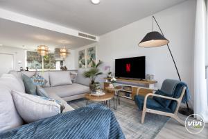 ein Wohnzimmer mit einem Sofa und einem TV in der Unterkunft Sonrisa in Estepona