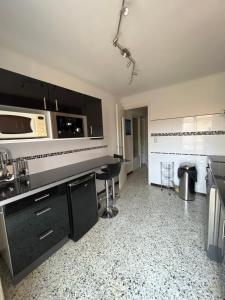 a kitchen with black cabinets and a counter top at Le mont canigou in Taurinya