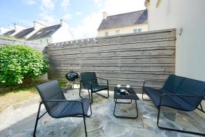 een groep stoelen en een tafel op een patio bij L'écume in Concarneau