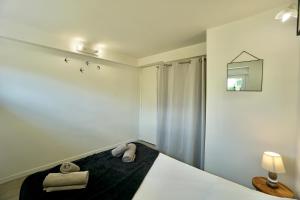 een slaapkamer met een bed met twee handdoeken erop bij L'écume in Concarneau