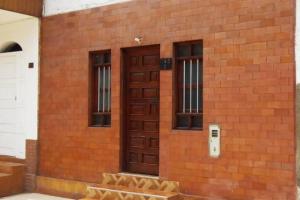 - un bâtiment en briques avec une porte et des fenêtres marron dans l'établissement Beautiful apartment/Hermoso apartamento!, à Lima