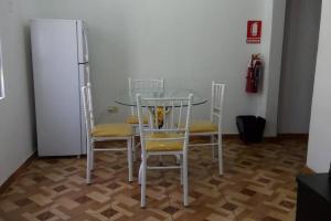 une table en verre avec quatre chaises et un réfrigérateur dans l'établissement Beautiful apartment/Hermoso apartamento!, à Lima