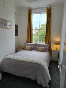 a bedroom with a large bed and a window at Gorgeous Sea View Apartment 5 mins To The Beach in St. Leonards