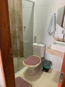 a bathroom with a toilet and a glass shower at Dunas Residence Casa n16 in Santo Amaro