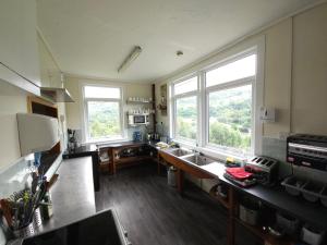 una cucina con due lavandini e due finestre di West Highland Lodge a Kinlochleven