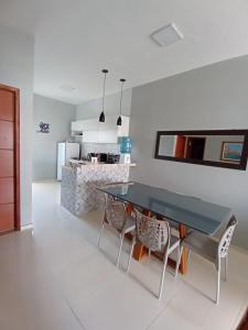 a kitchen with a dining room table and chairs at Dunas Residence Casa n16 in Santo Amaro