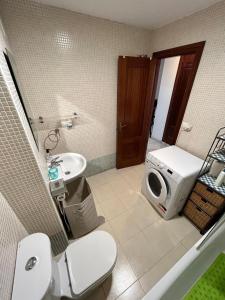 a bathroom with a toilet a sink and a microwave at Apartamento Atico Algeciras in Algeciras