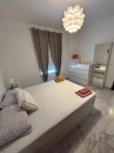 1 dormitorio con 1 cama grande con espejo y lámpara de araña en Apartamento Atico Algeciras en Algeciras