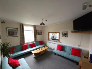 a living room with a blue couch and red pillows at West Highland Lodge in Kinlochleven