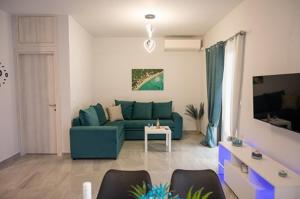 トロにある3S Tolo Apartmentsの青いソファとテーブルのあるリビングルーム