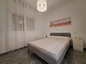 a white bedroom with a bed and a lamp at Altamira White & Bright in Almería