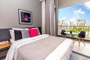 sypialnia z dużym łóżkiem i dużym oknem w obiekcie 360 Suítes VN Turiassú by Housi - Apartamentos mobiliados w São Paulo