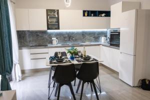 トロにある3S Tolo Apartmentsのキッチン(小さなテーブル、椅子2脚付)