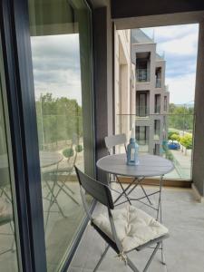 a table and a chair on a balcony with a window at ATEA apartments in Kavarna