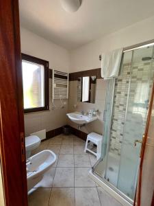 un bagno con due lavandini e una doccia di Locazione Turistica Senabrinu a Suni Altre 22 foto
