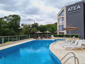 a pool at a hotel with chairs and umbrellas at ATEA apartments in Kavarna