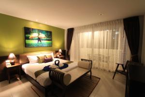 a bedroom with a bed and a table and a window at Sleep Easy in Kata Beach