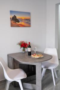 uma mesa com uma pizza e uma garrafa de vinho em 3S Tolo Apartments em Tolo
