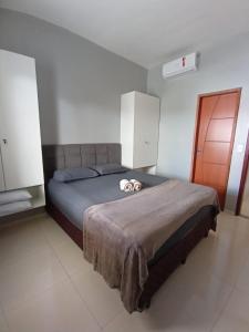 a bedroom with a bed with two slippers on it at Dunas Residence Casa n16 in Santo Amaro