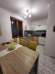 a kitchen with a wooden table and yellow chairs at Zwaan Apartmány in Dunajská Streda