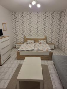 a bedroom with a bed and a table in it at Zwaan Apartmány in Dunajská Streda