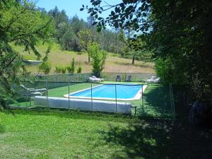 a fence around a swimming pool in a yard at Les Gites Accromagnon, Climatisation in Les Eyzies-de-Tayac