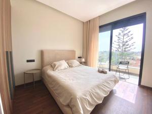 a bedroom with a large bed and a large window at NEW modern 1 BR, 1min fr tramway in Casablanca
