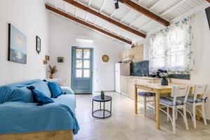 a kitchen and living room with a blue couch and a table at Venus Studio in Stafylos