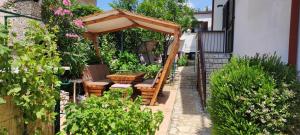 een tuin met een tafel en stoelen onder een parasol bij Apartments Svjeta in Jadranovo