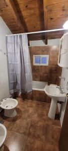拉安戈斯圖拉鎮的住宿－Blue House 5 Villa La Angostura，浴室配有2个盥洗盆、淋浴和浴缸。