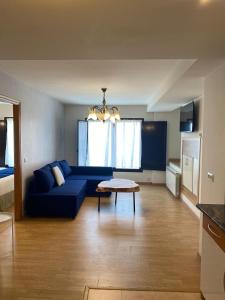 un soggiorno con divano blu e tavolo di Apartamentos Palacio Azcárate Calle Calvario a Ezcaray