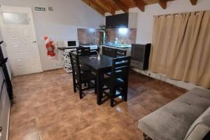 uma cozinha com uma mesa preta e cadeiras num quarto em Blue House 5 Villa La Angostura em Villa La Angostura
