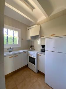una cucina con armadietti bianchi e frigorifero bianco di Apartaments Margarita Sabina Pinell a Platja  d'Aro