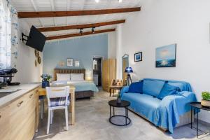 ein Wohnzimmer mit einer blauen Couch und einem Bett in der Unterkunft Venus Studio in Stafylos
