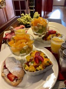 The Old Liberty Schoolhouse في Azle: طاولة مع طبقين من طعام الإفطار وأطباق من الفاكهة